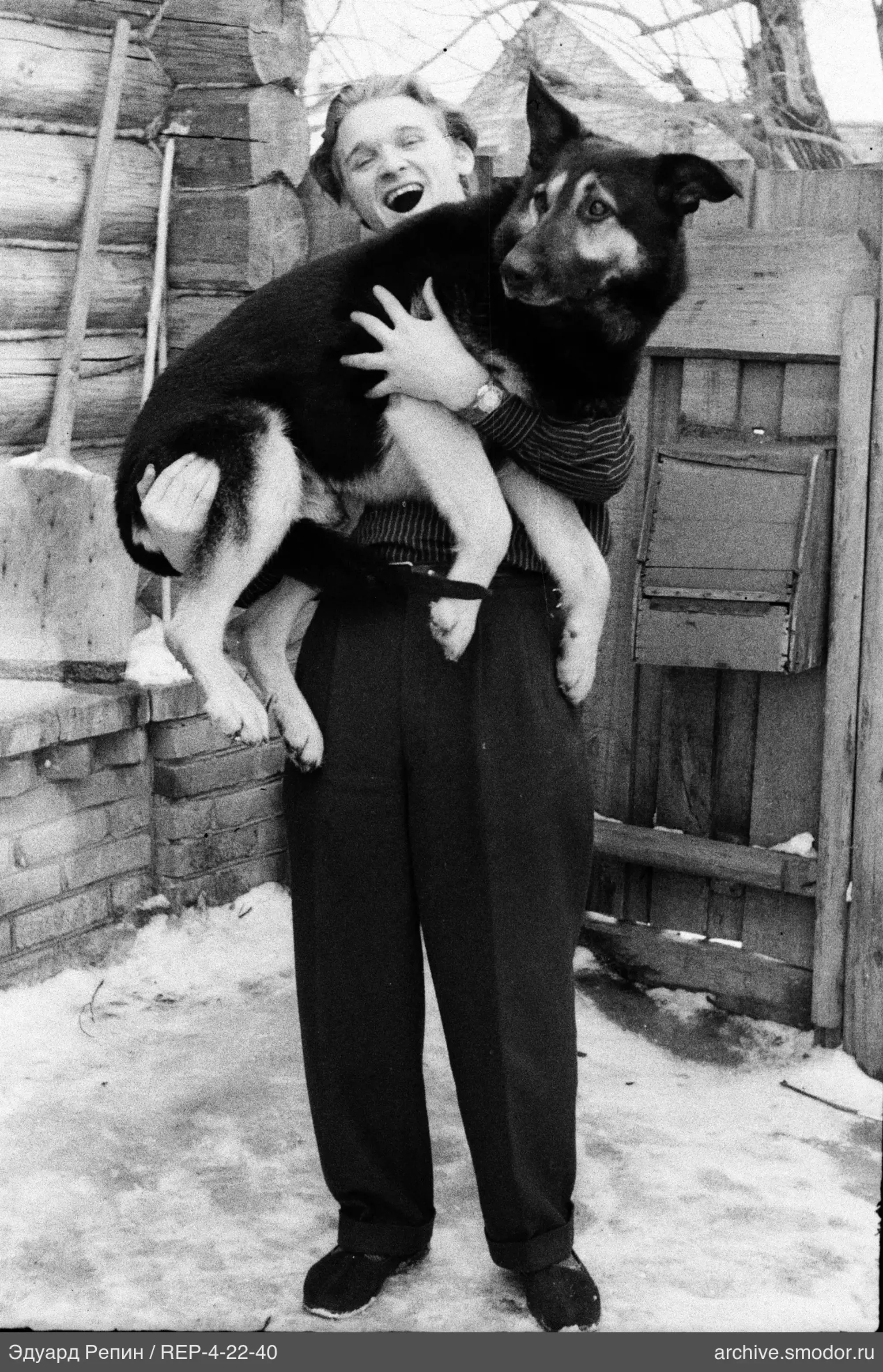 Mann mit Hund bei Holzzaun