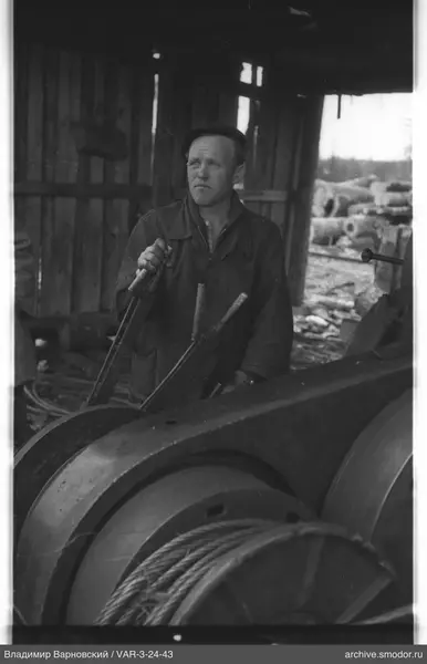 Man at a mechanism with levers and cable