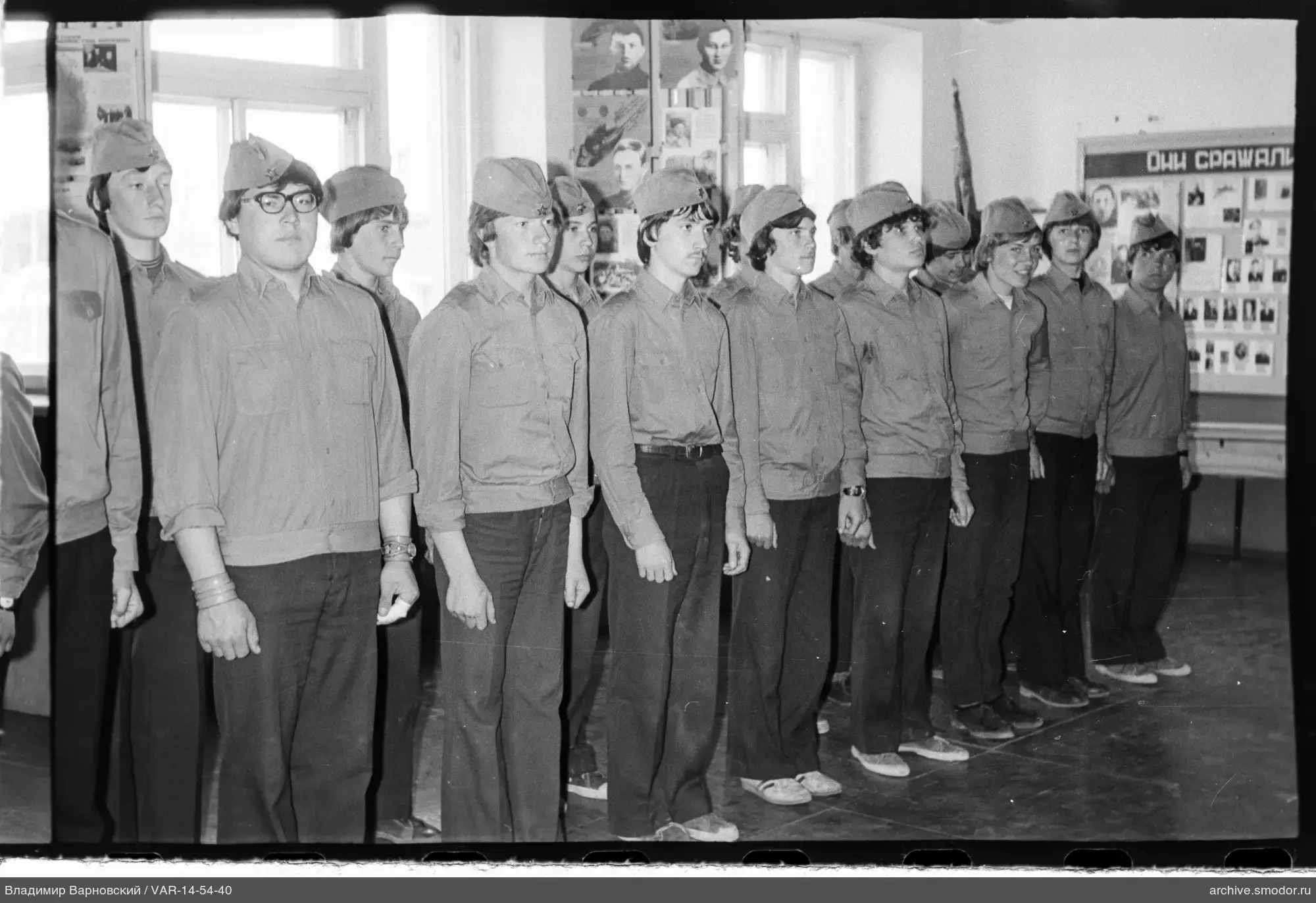 Gruppe junger Menschen in Uniform mit Pilotmützen