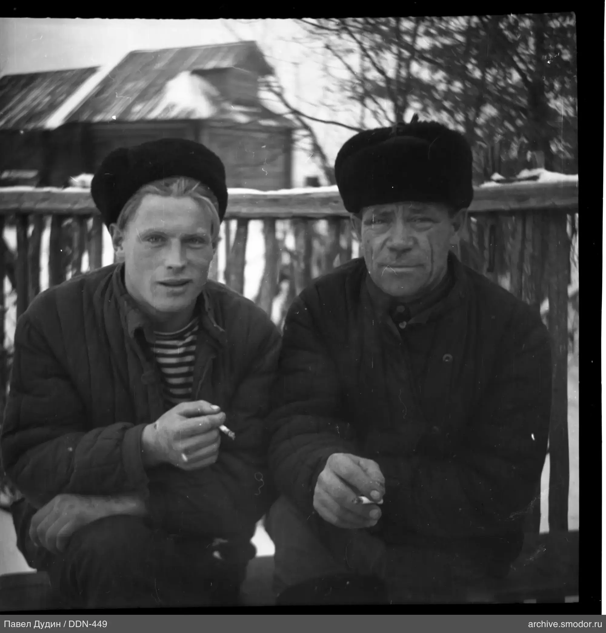 Два мужчины на скамейке у домов
