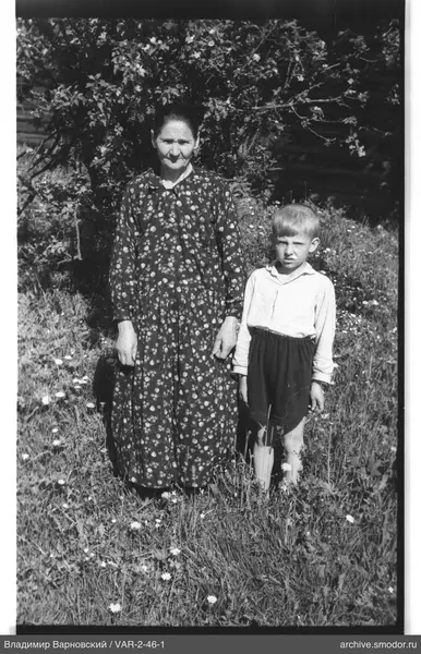 Frau und Junge auf grasbewachsenem Bereich mit Blumen