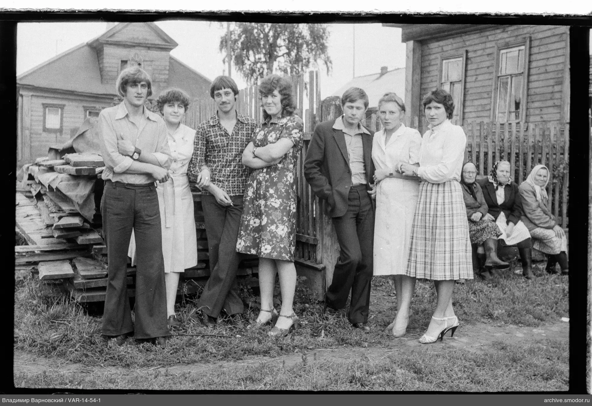 Group portrait by a wooden fence