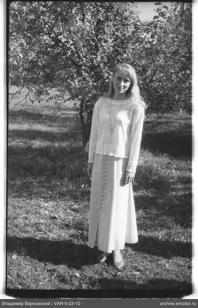 Frau in Kleid und Pullover in der Natur