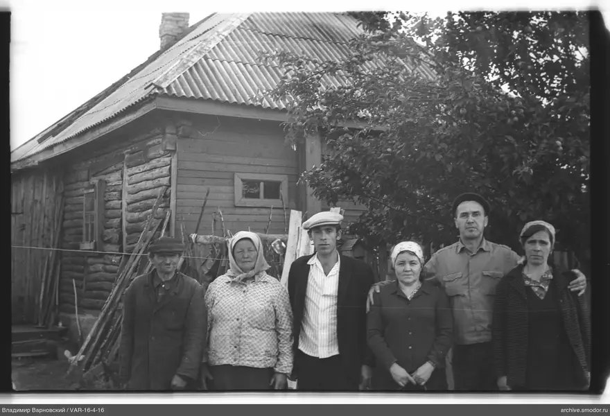 Gruppenporträt vor Haus und Apfelbaum