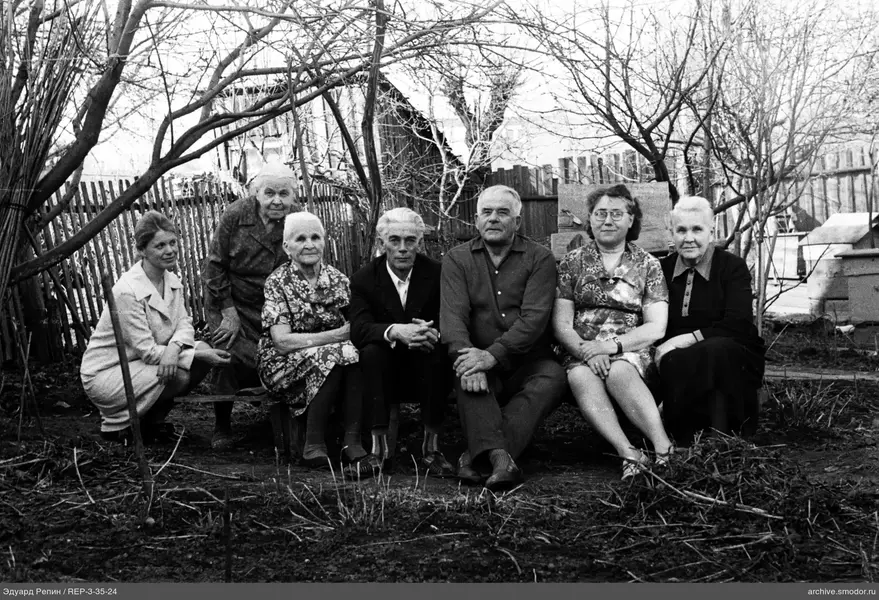 Gruppe von Menschen im Garten sitzend und hockend