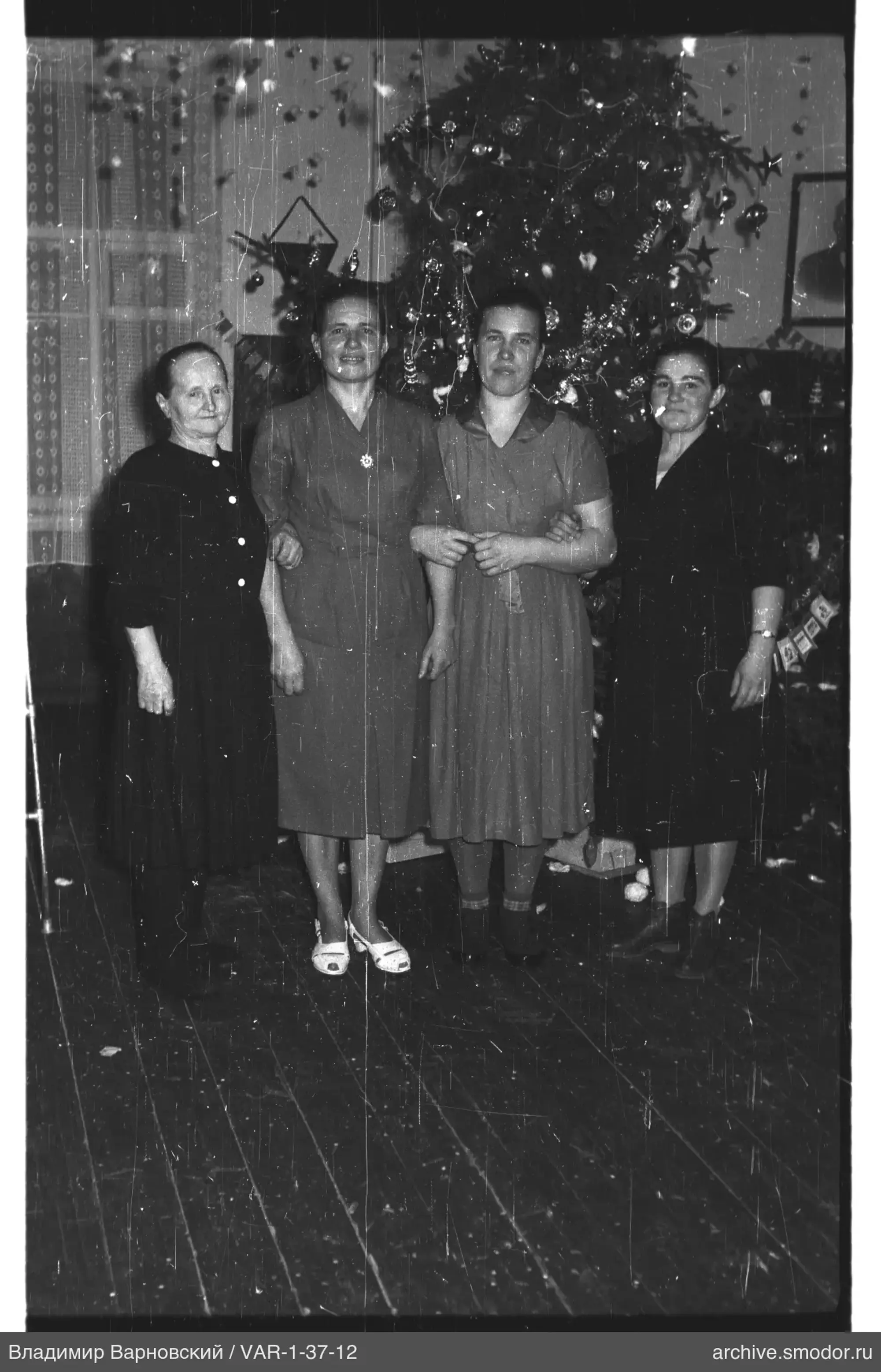 Gruppenporträt von Frauen vor Weihnachtsbaum
