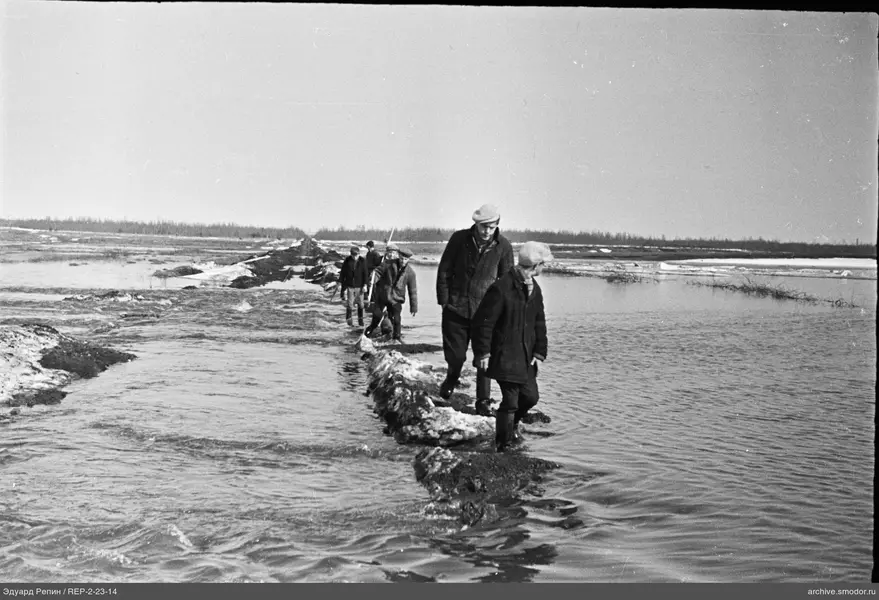 Männer auf schmalem Damm am Wasser