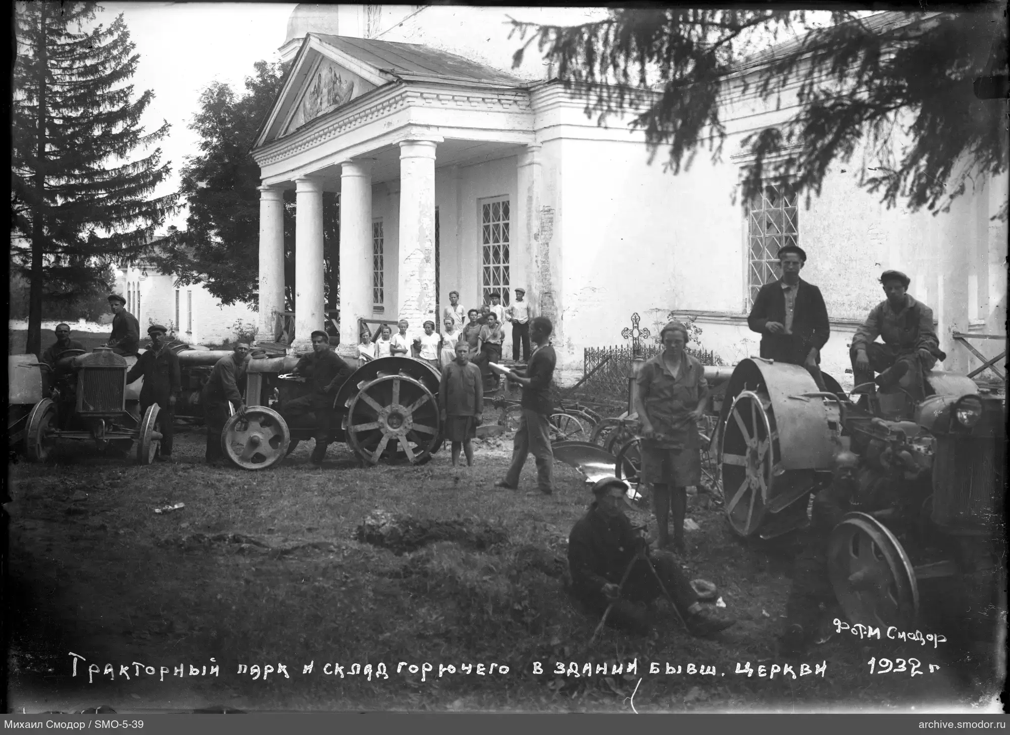 Группа людей и тракторы перед зданием