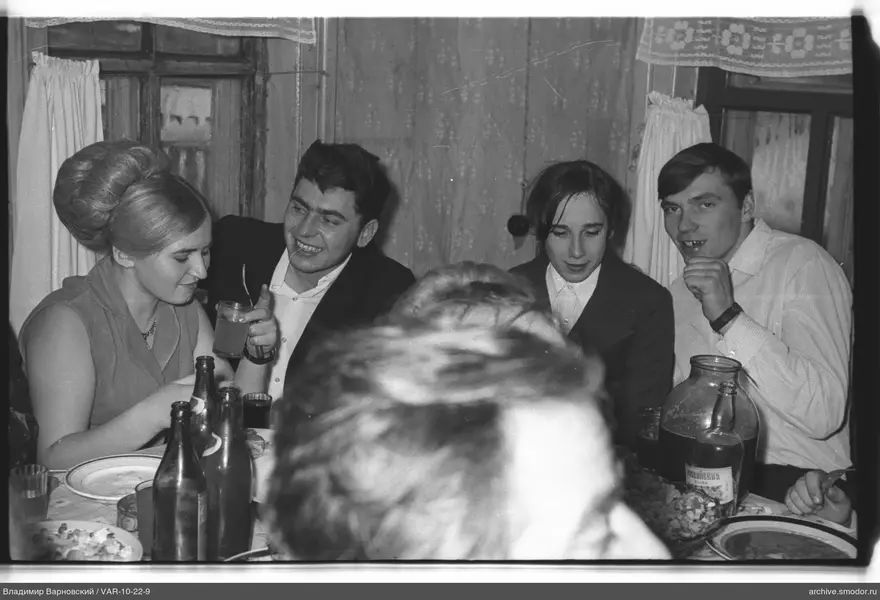 Group sitting at a table with dishes and bottles