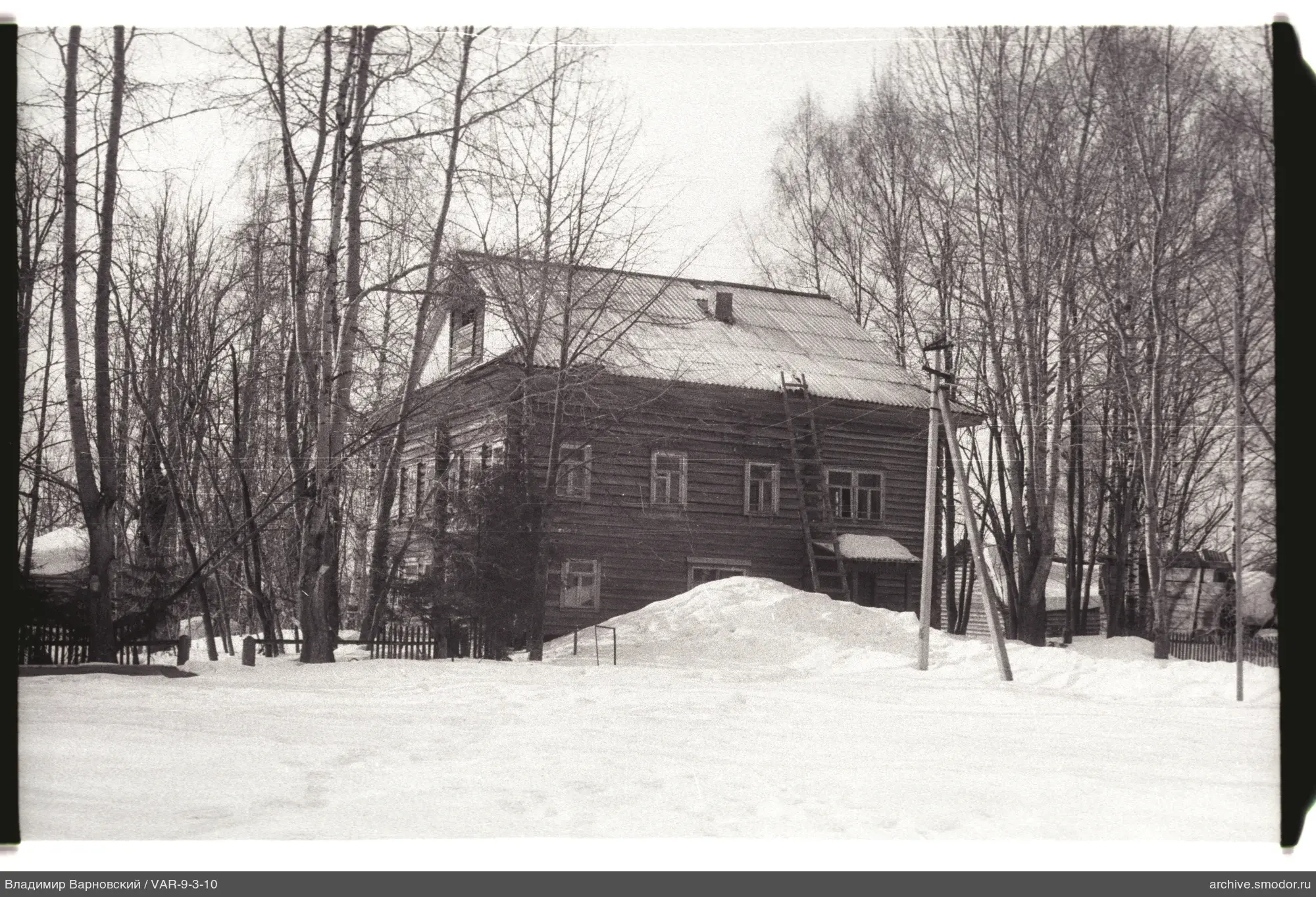 Holzhaus mit Mansardfenster und Schneehaufen