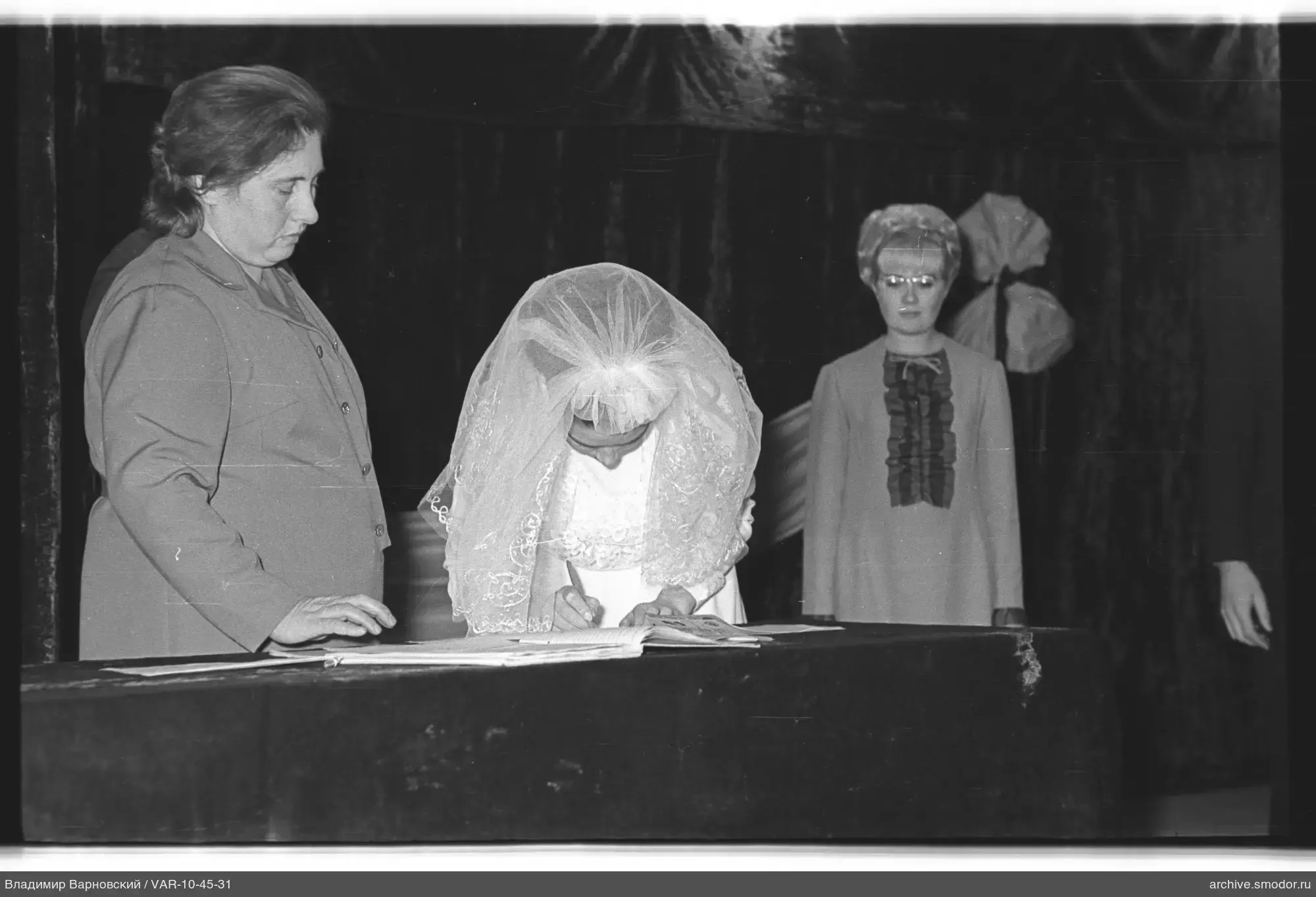 Woman in wedding dress signing a document