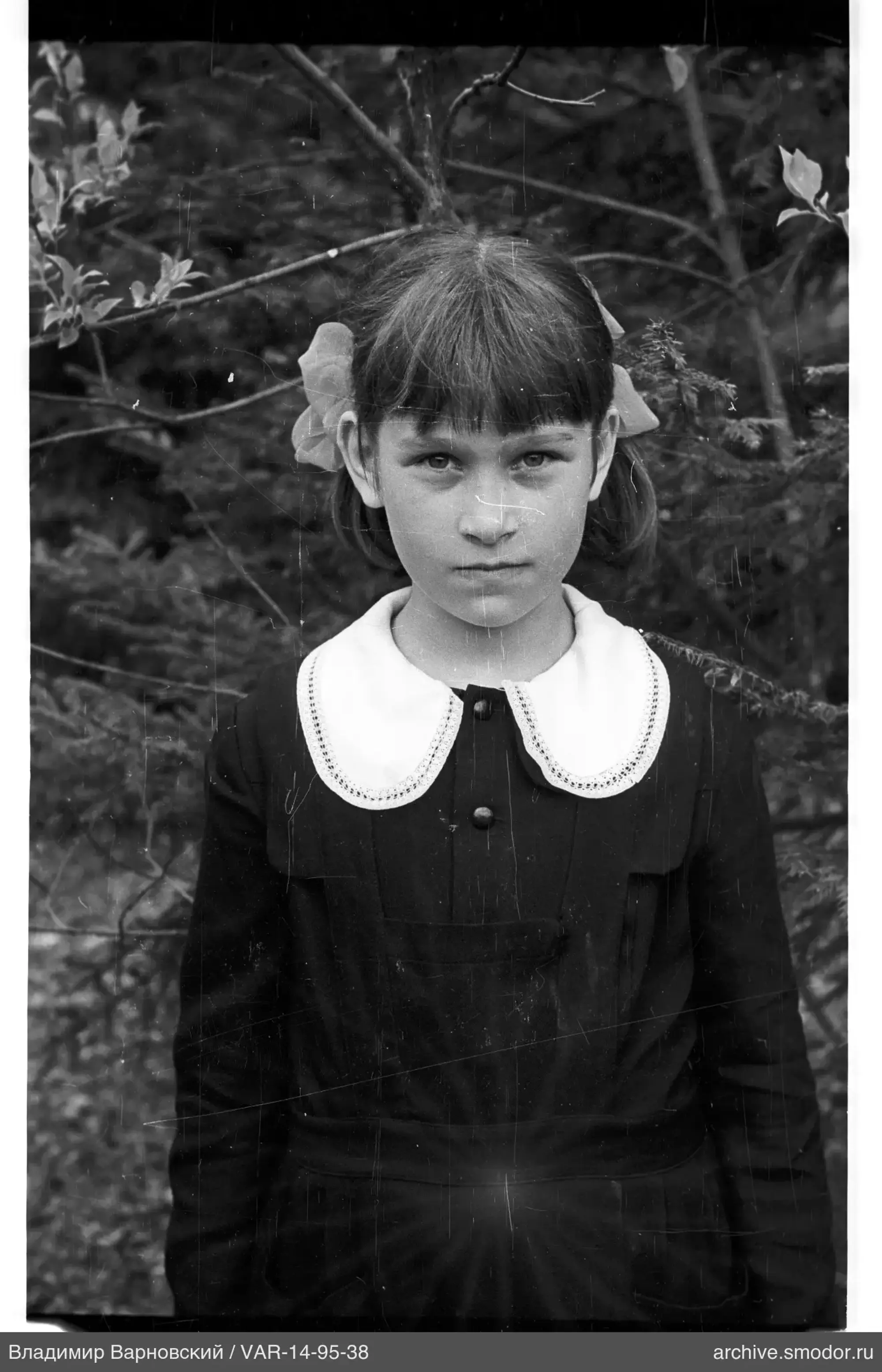 Mädchen in dunklem Kleid mit Schleifen