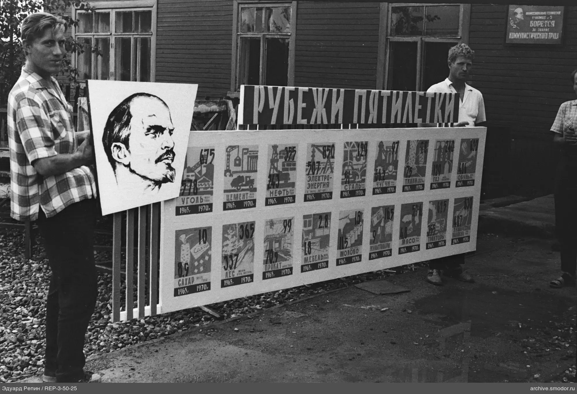 Gruppe von Männern mit Plakat vor Holzgebäude