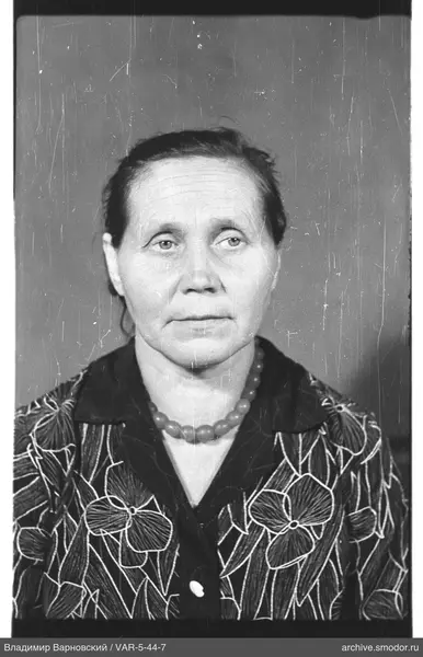 Porträt einer Frau mit Halskette und Blumenbluse