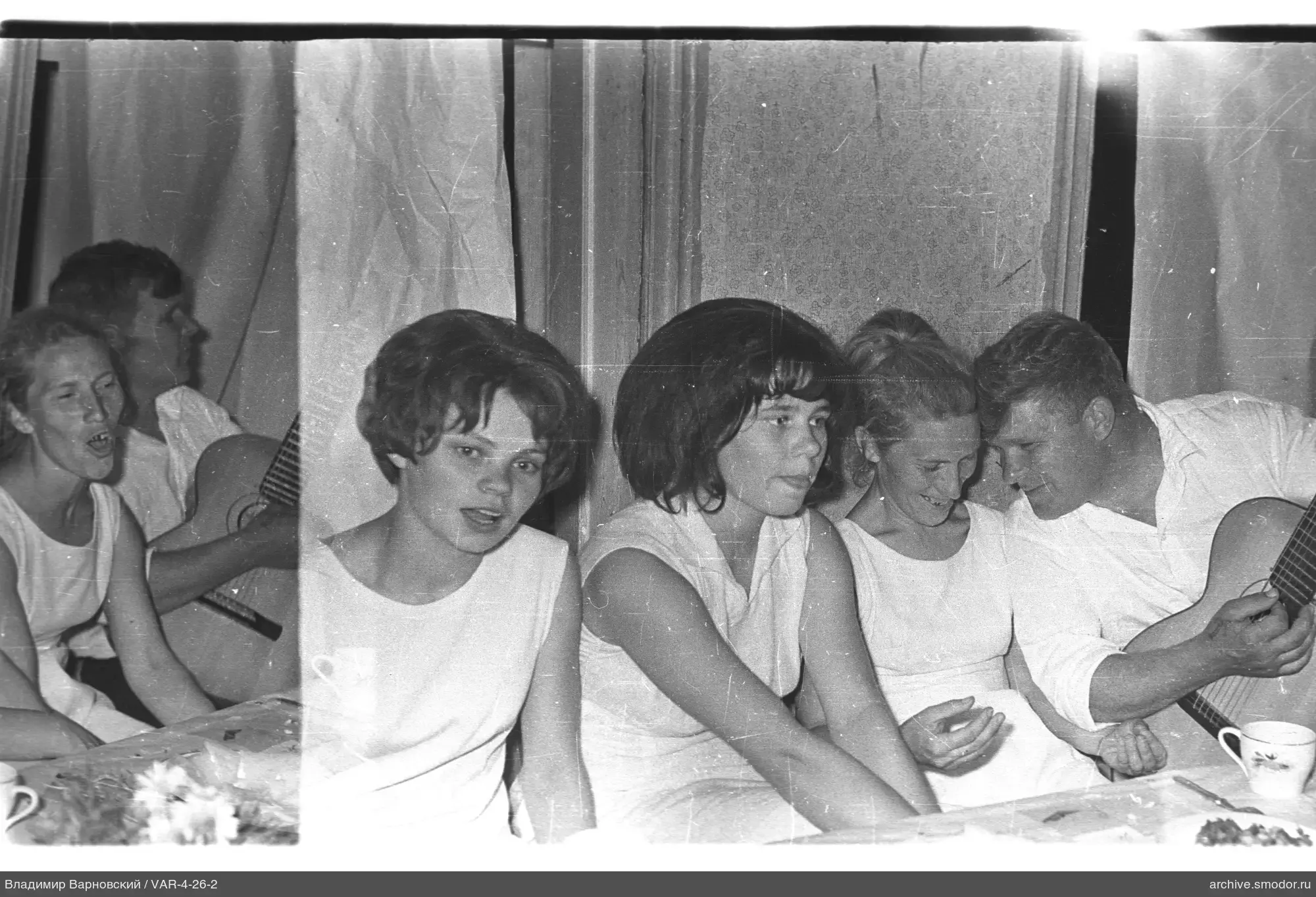 Gruppe am Tisch mit Tassen und Blumen