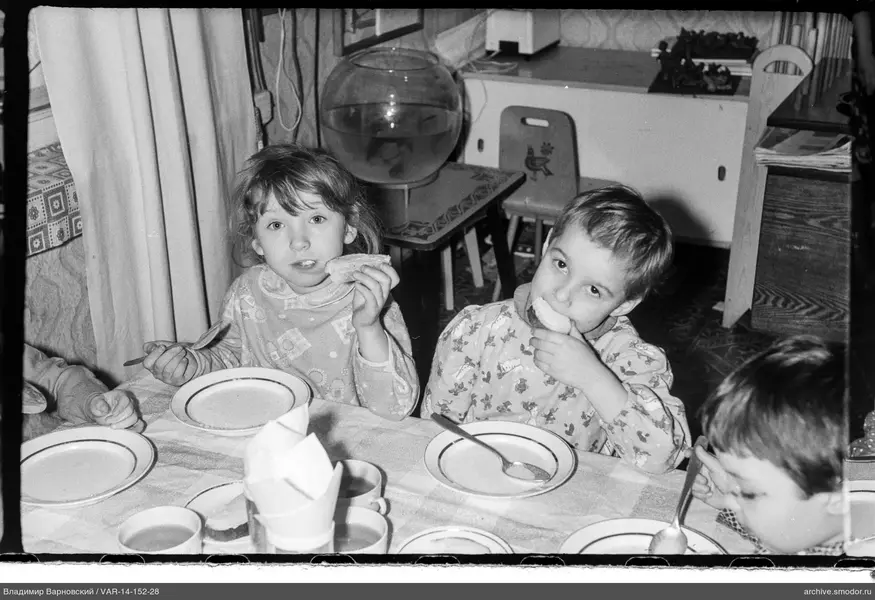 Kinder am Tisch mit Brot und Geschirr