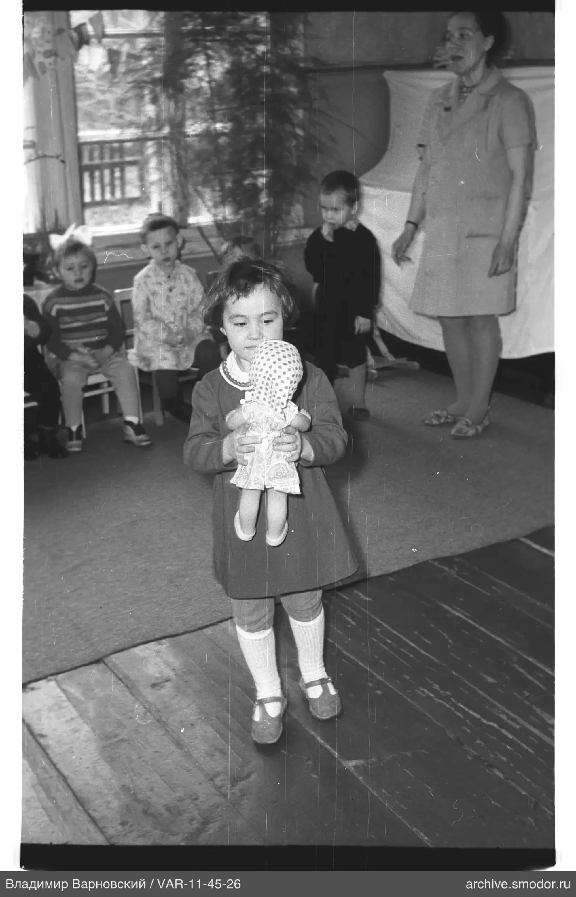 Mädchen mit Puppe und Familie im Raum