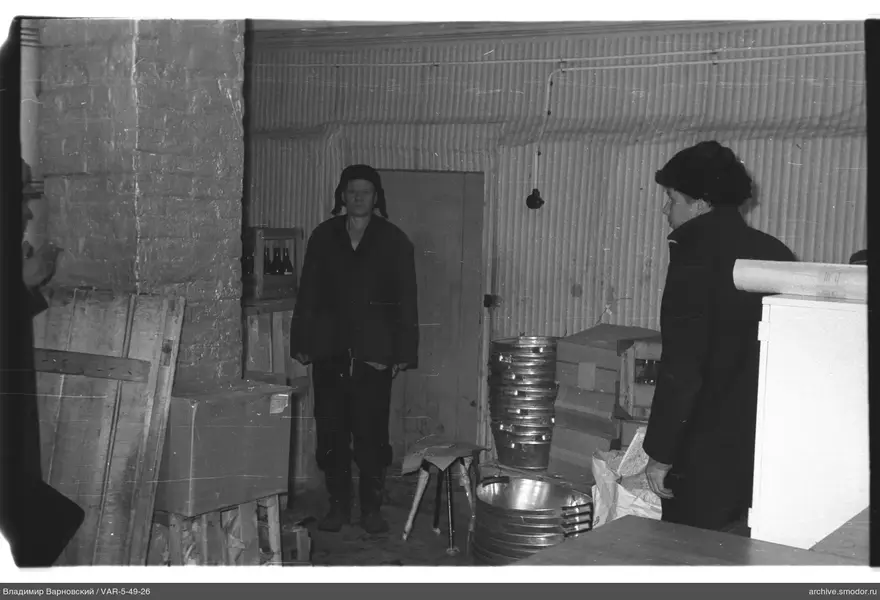 Zwei Männer in einem Raum mit Backsteinwand und Metallverkleidung