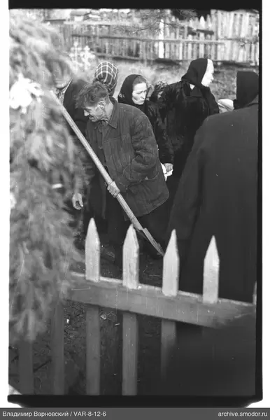 Man digging ground with women around