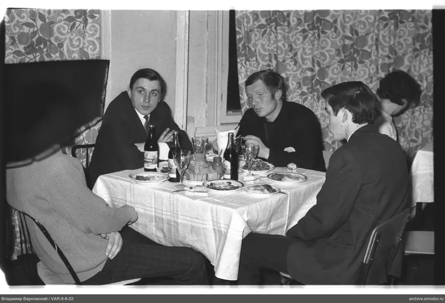 Men sitting at a table with food and drinks