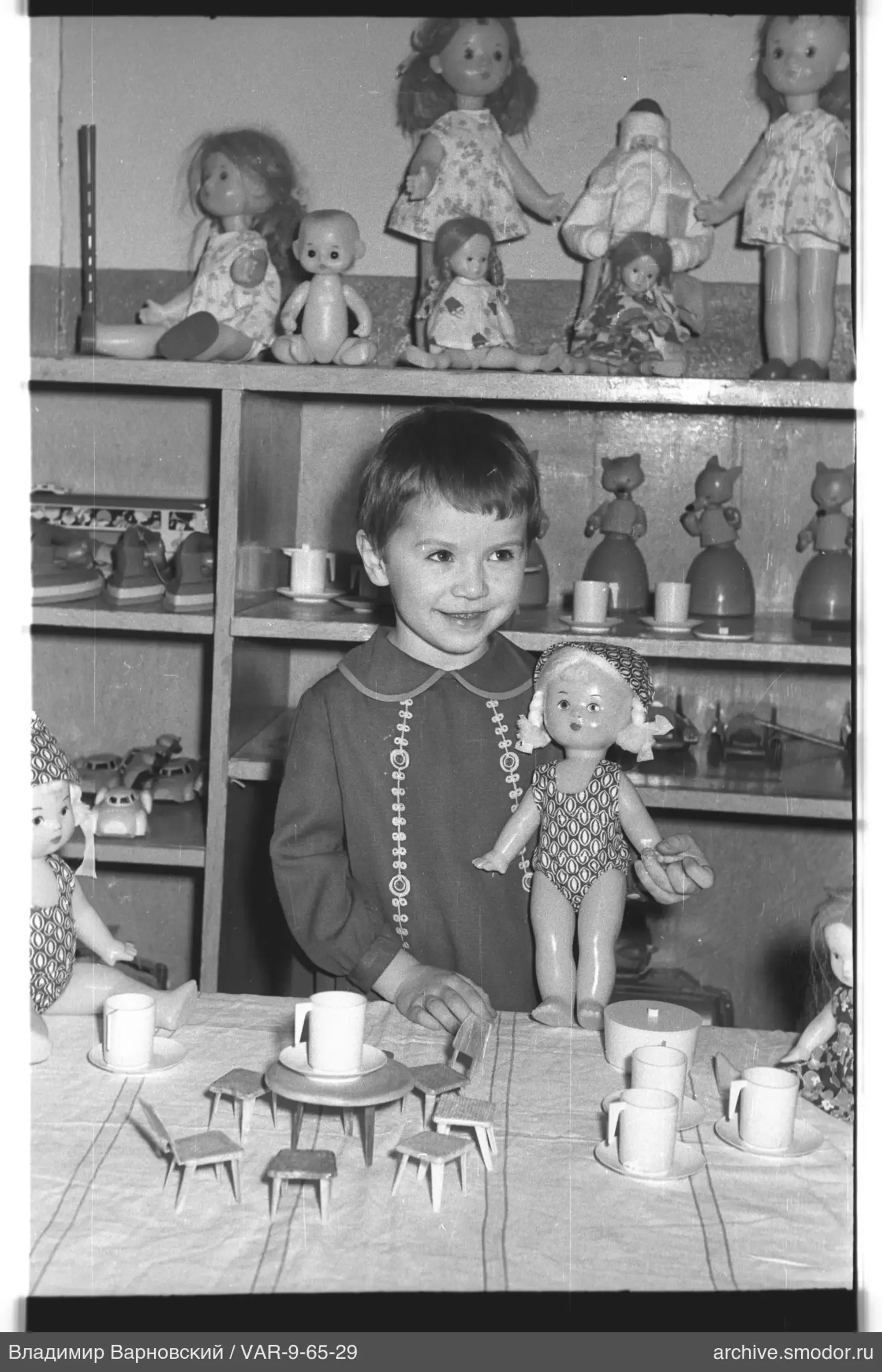 Kind mit Puppe am Spieltisch