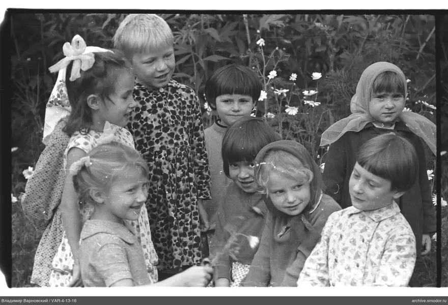 Gruppe von Kindern vor hohem Gras und Blumen