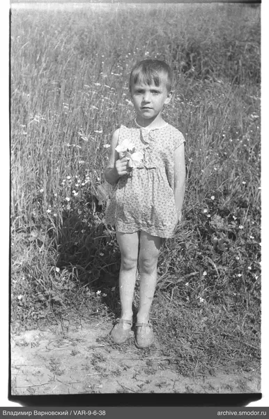 Mädchen mit Blumen vor hohem Gras