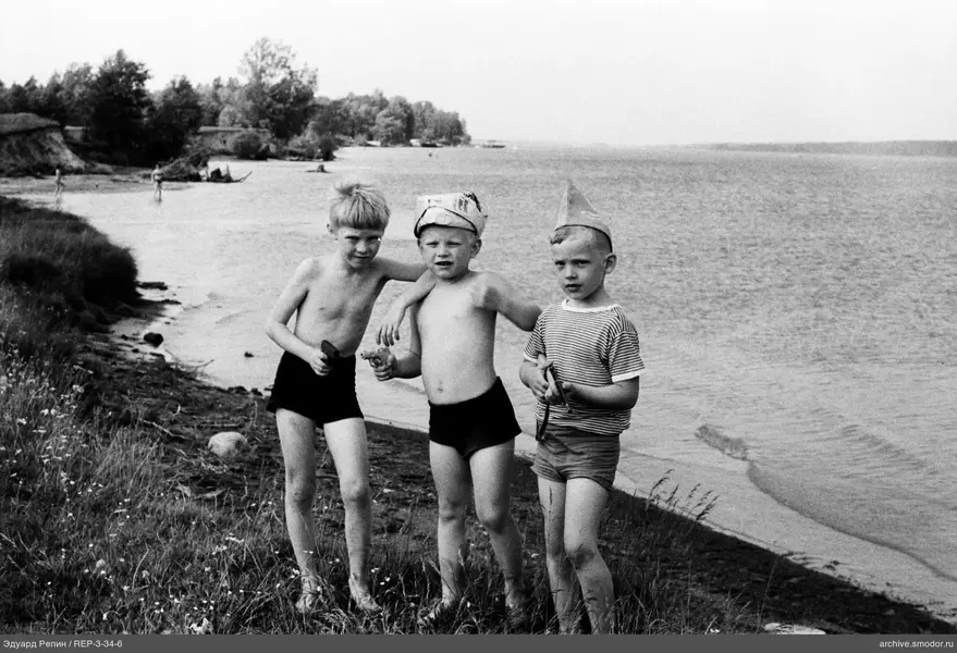 Drei Jungen mit Spielzeugwaffen am Wasser