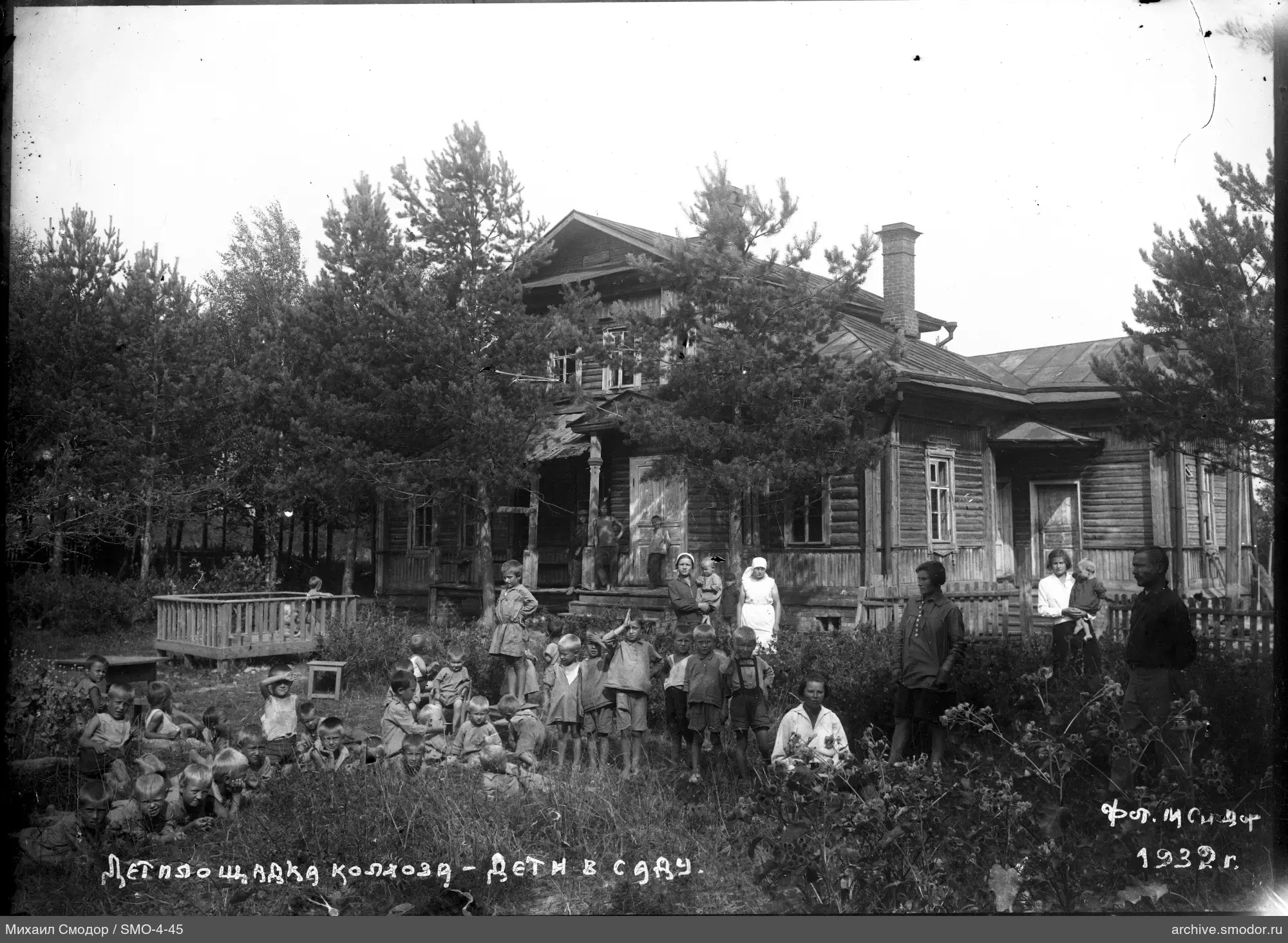 Gruppe von Kindern und Erwachsenen am Holzgebäude