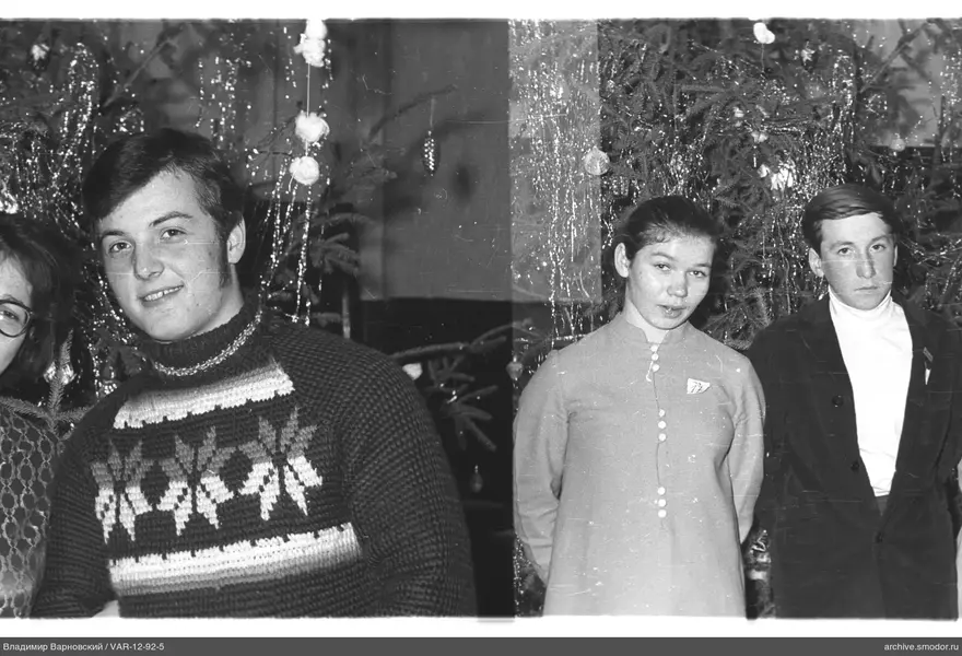 Gruppenporträt vor geschmücktem Weihnachtsbaum