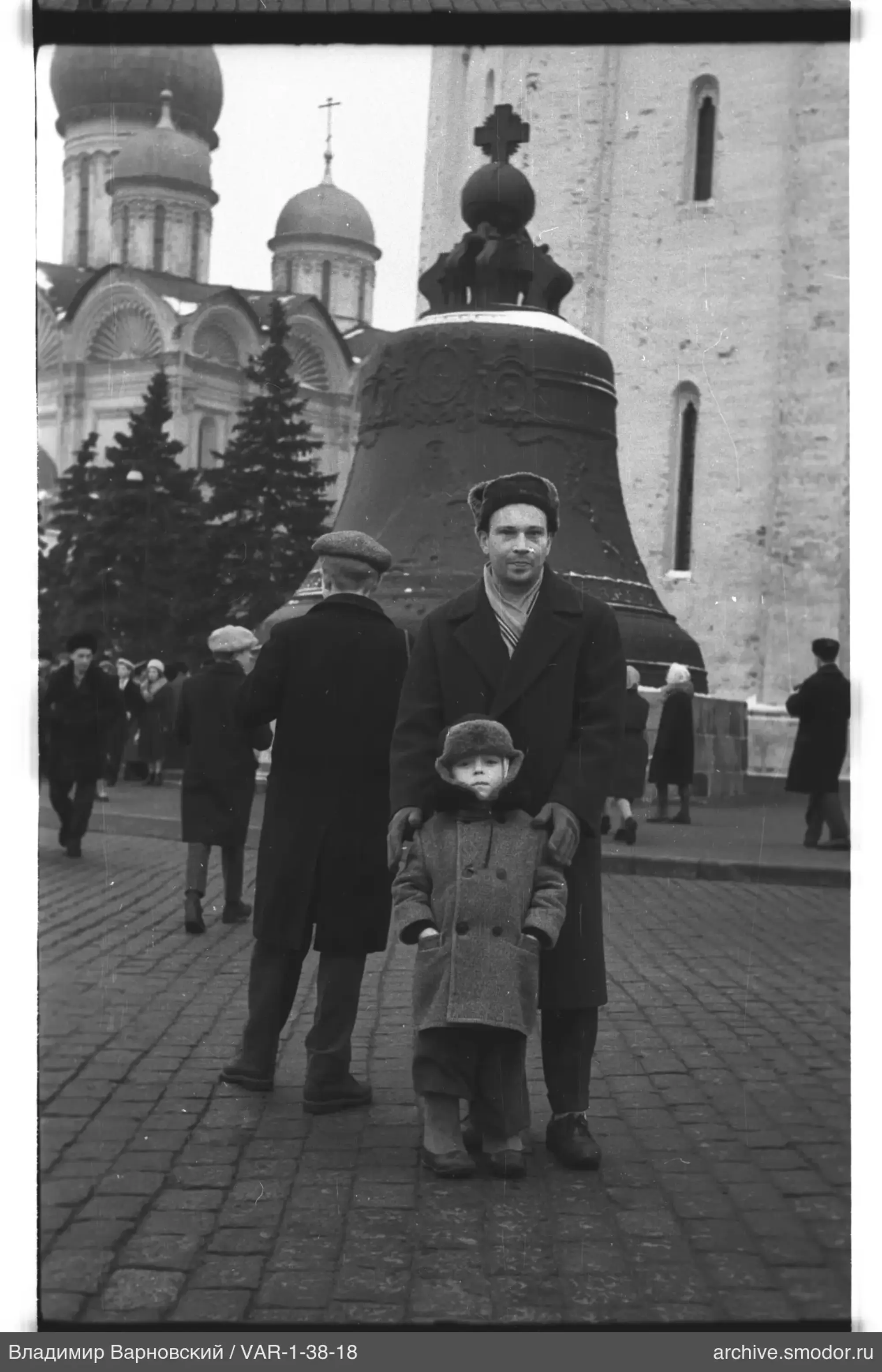 Mann und Kind vor einer Glocke