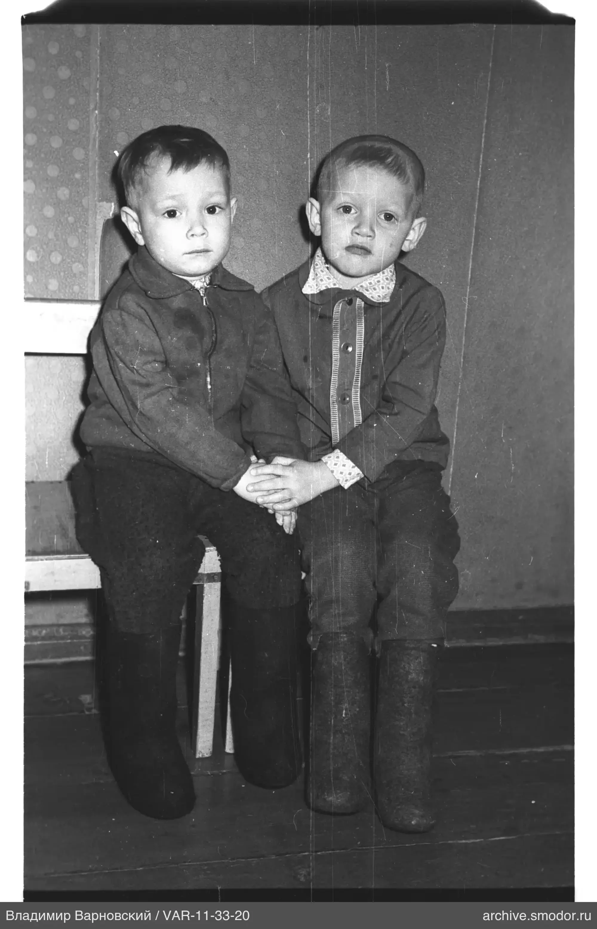 Zwei Jungen auf einer Bank an der Wand