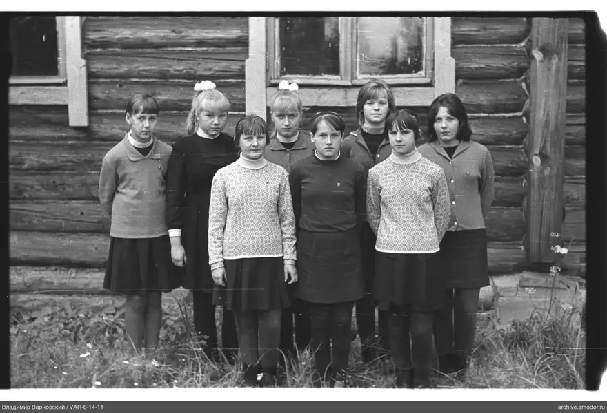 Gruppe von Mädchen vor einem Holzhaus