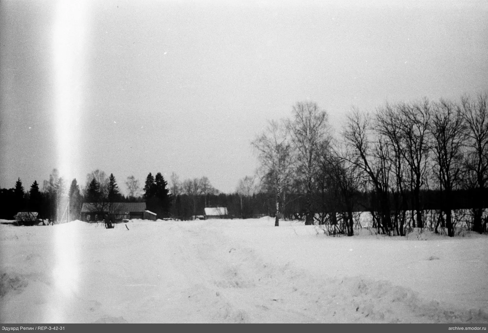 Schneebedecktes Feld mit Straße und Häusern