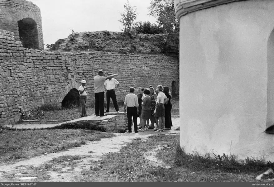 Gruppe an einer Steinmauer mit Bögen