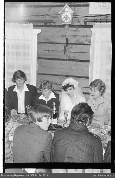 Gruppe am Tisch mit einer Frau im Hochzeitskleid