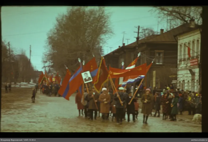Gruppe mit Fahnen und Porträt