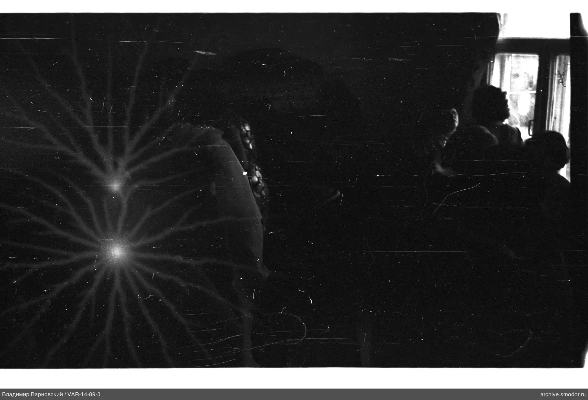 People by the window in a dark room