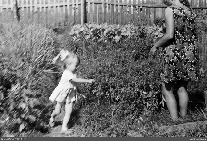 Mädchen mit Schleife und Frau im Garten