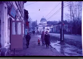 Улица с женщинами и детьми у здания с куполом