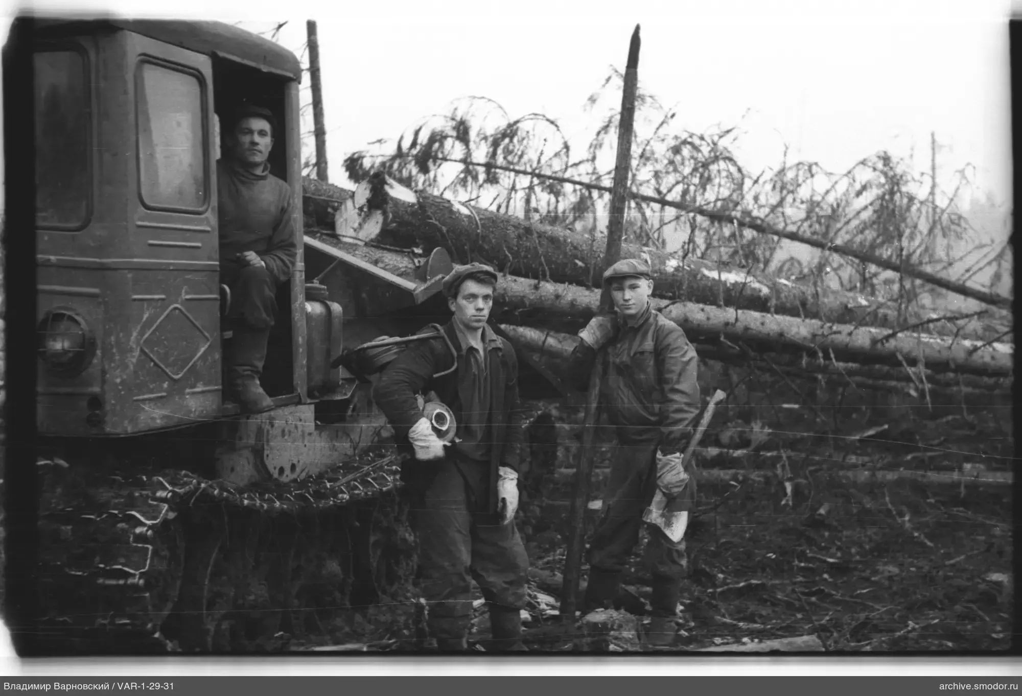 Gruppe von Männern mit Traktor und Werkzeugen