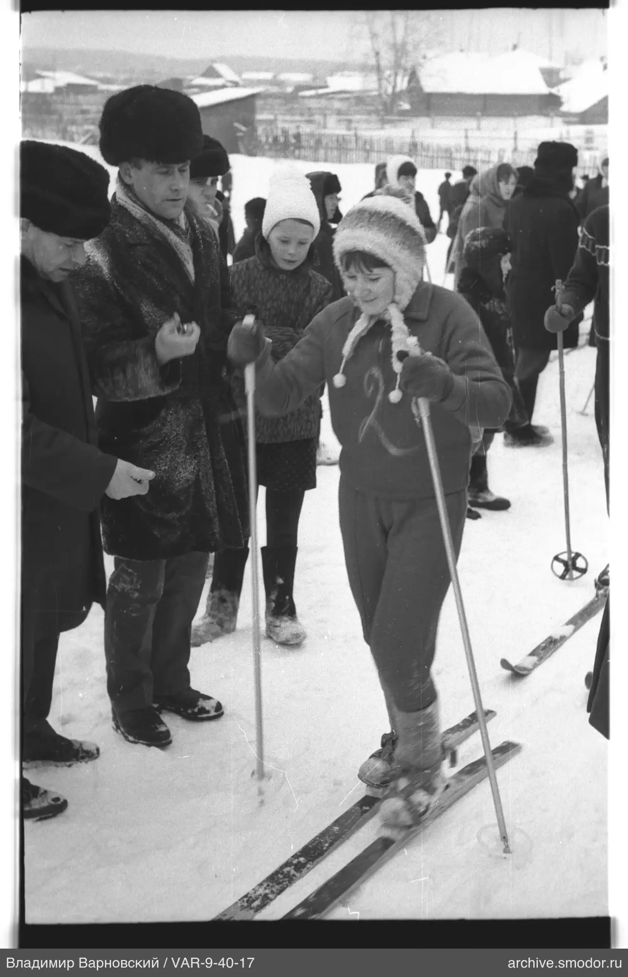 Mädchen auf Skiern mit Erwachsenen im Schnee