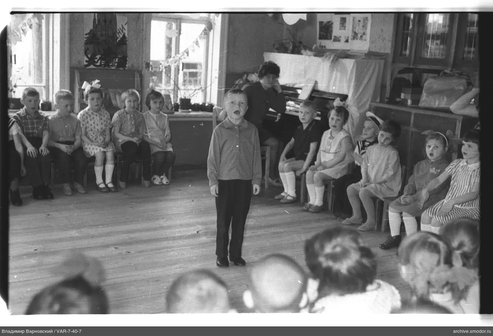 Children and woman at piano in room