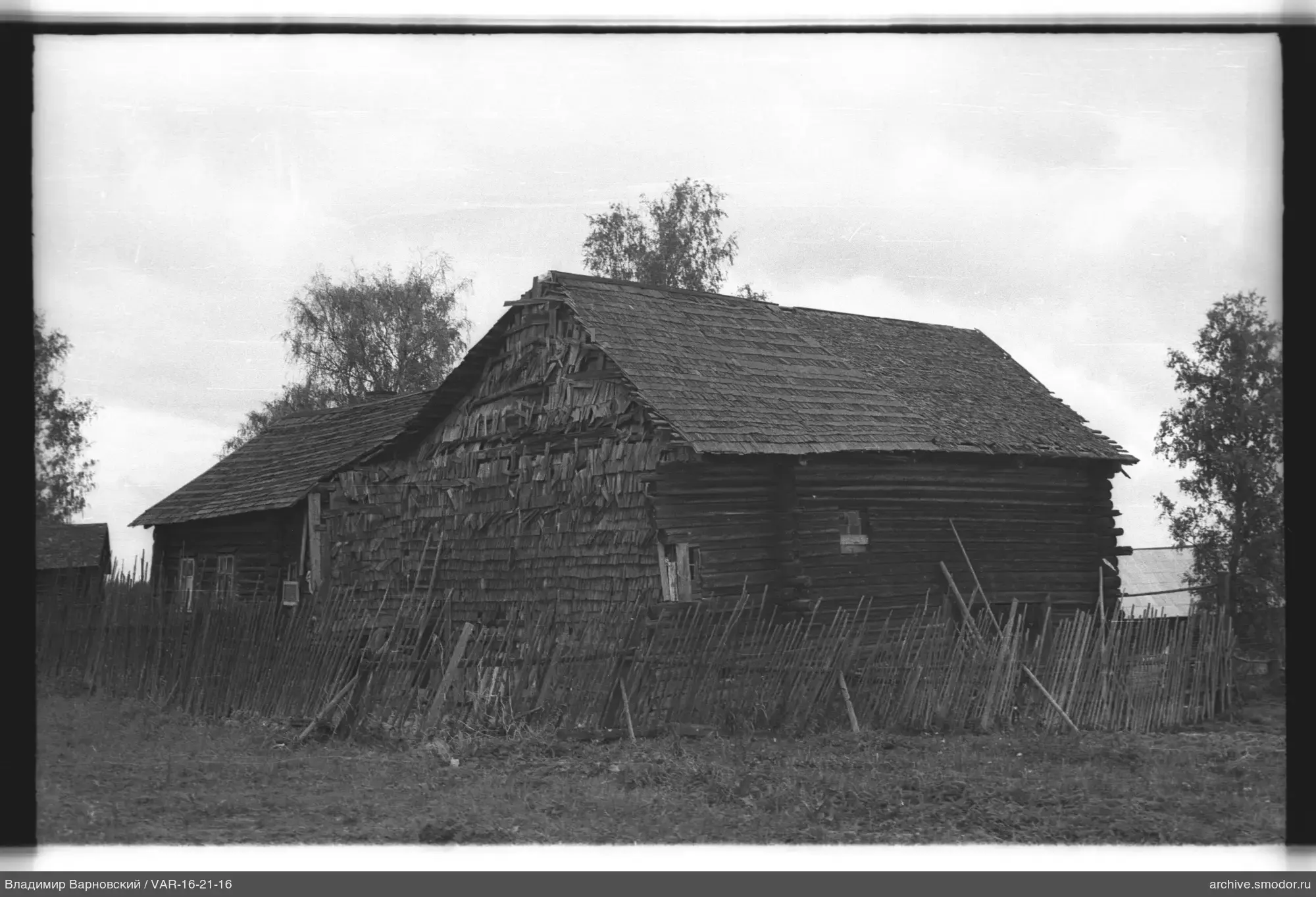 Holzgebäude mit Satteldach und Zaun