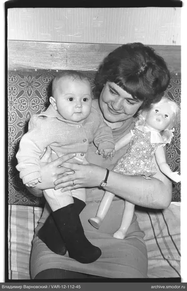 Woman with child and doll on sofa