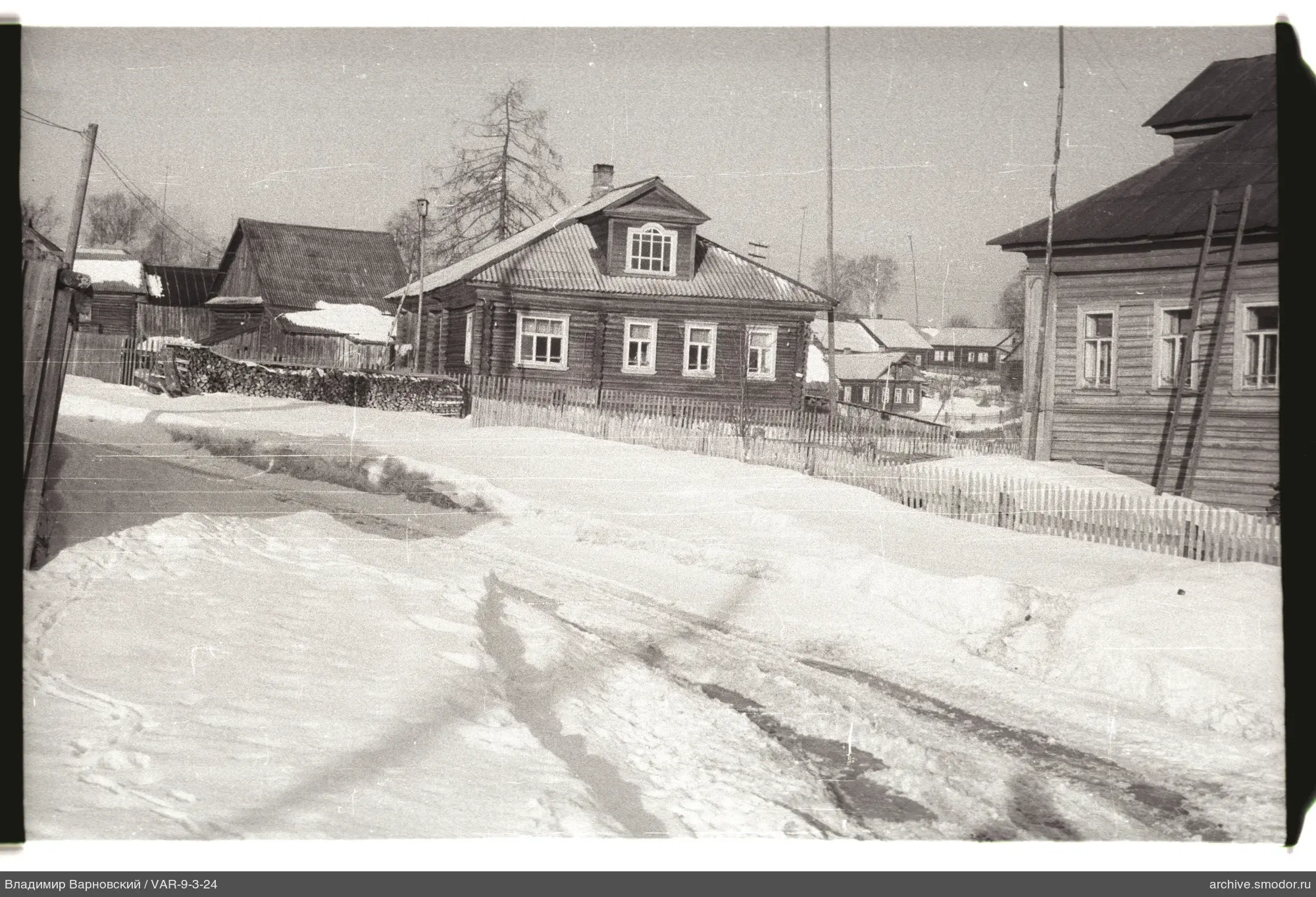 Verschneite Straße mit Holzhäusern