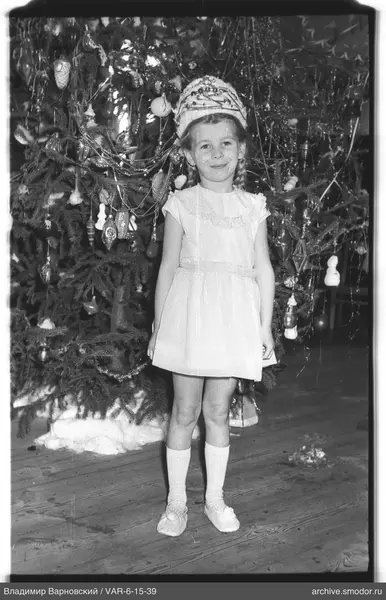 Mädchen vor geschmücktem Weihnachtsbaum