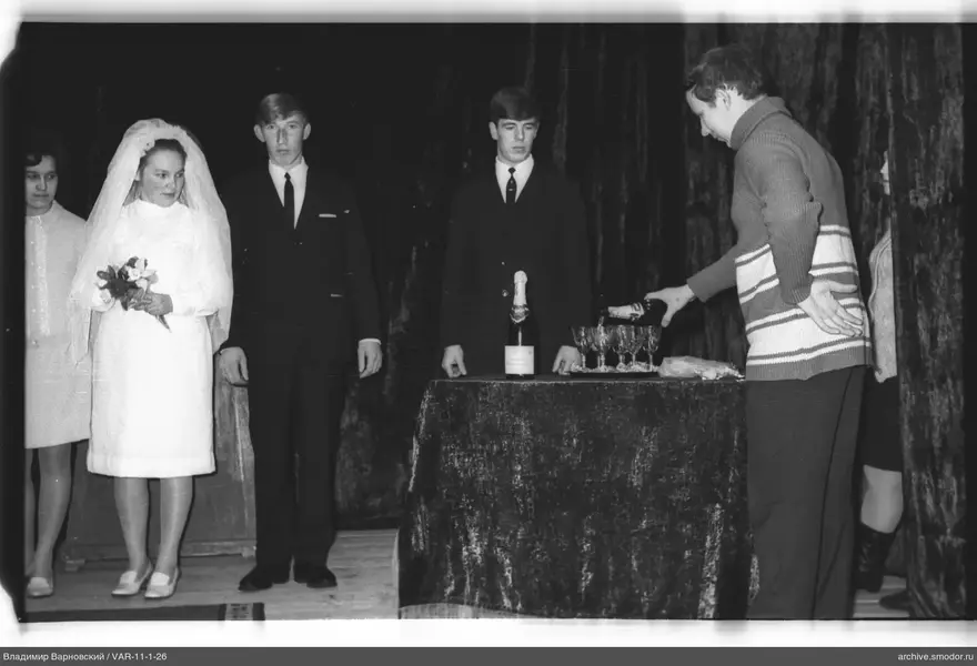 Group on stage in front of velvet curtain