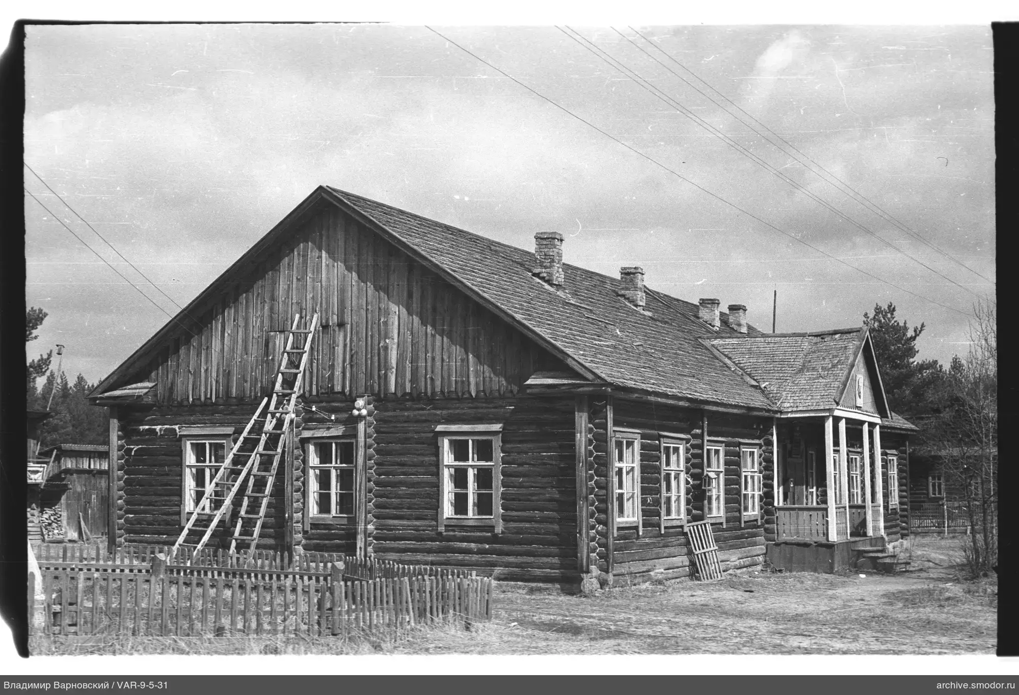 View of wooden building with ladder and porch