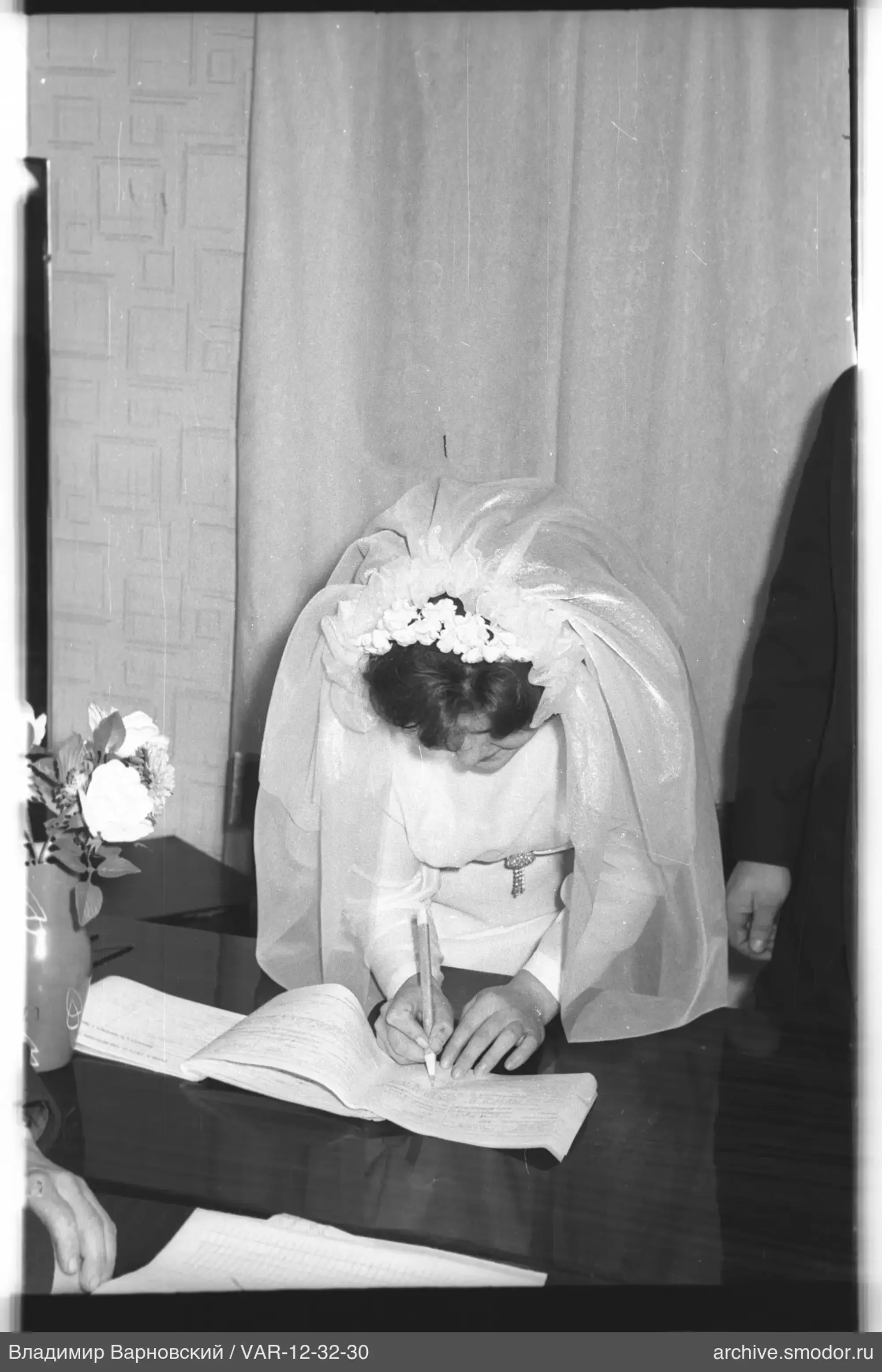 Woman in wedding dress signing a document